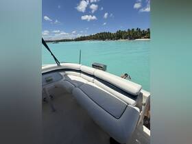 A cozy seating area inside a boat, overlooking stunning turquoise waters and a beach, perfect for relaxing during a day on the water.