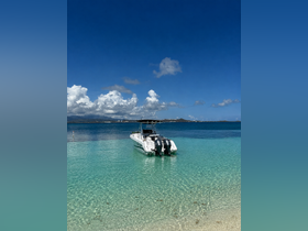 A sleek speedboat is docked in crystal-clear waters, surrounded by a stunning tropical backdrop — perfect for a day of adventure on the sea.