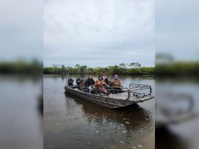 A group of friends enjoys a day on the water aboard an airboat, perfect for fishing and outdoor adventures in nature.