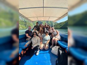 A lively group of friends enjoys a boat trip surrounded by stunning mountain scenery, perfect for creating unforgettable memories on the water.