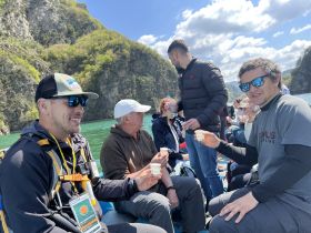 A lively group enjoys drinks while boating, surrounded by stunning natural scenery — perfect for social gatherings and memorable experiences on the water.
