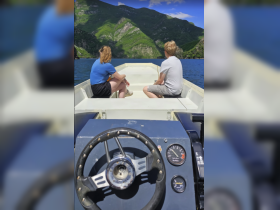 A scenic view from the boat featuring a couple enjoying the stunning mountainous landscape — a perfect moment for exploration on the water.