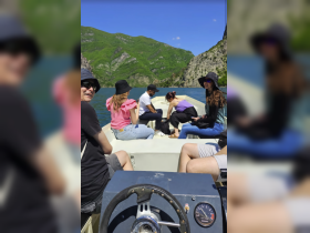 A lively group enjoys a boat ride on a scenic lake surrounded by lush mountains, perfect for adventure and exploration.