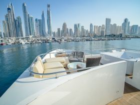 A luxurious lounge area on a yacht, showcasing comfortable seating with a stunning view of Dubai's skyline — perfect for relaxing while enjoying the cityscape.