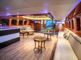 A spacious and elegantly designed interior of a boat featuring comfortable seating and modern amenities, perfect for relaxing during a day on the water.