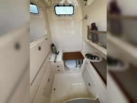 Interior view of a boat's cabin featuring a compact bathroom setup, showcasing practical amenities for comfort on the water.