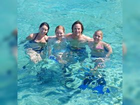 A joyful family enjoys a refreshing swim in crystal-clear waters, creating unforgettable memories during their aquatic adventure.