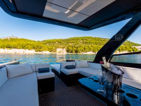 A stylish interior view of a luxury boat's lounge area, featuring comfortable seating and a chilled bottle of champagne, perfect for relaxing on the water.