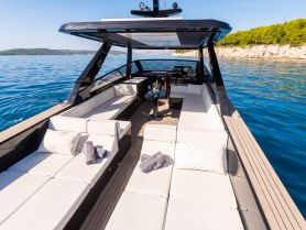 A spacious and stylish lounge area inside a luxury boat, featuring comfortable seating and a serene view of the water, perfect for relaxation while cruising.