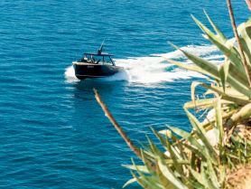 A sleek speedboat navigates through crystal-clear waters, showcasing the thrill of boating adventures on the open sea.