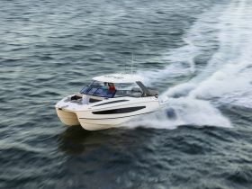A sleek catamaran speeds through the water with guests onboard, showcasing the thrill of boating adventures.