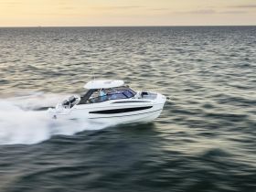 A sleek speedboat glides through the water at high speed, showcasing its dynamic design and performance on the open sea.