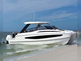 A sleek yacht rests on the shore, showcasing its elegant design against a backdrop of clear skies and gentle waves — perfect for luxury outings on the water.