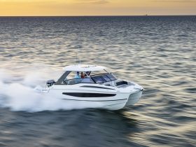 A couple enjoys a thrilling ride on a sleek yacht, cutting through the waves at sunset — perfect for adventure seekers on the water.