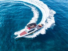 A stunning aerial view of a speedboat gracefully cutting through the clear blue waters, showcasing its sleek design and dynamic movement.
