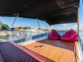 A cozy lounge area on a boat featuring comfortable bean bags, perfect for relaxing while enjoying views of the marina.
