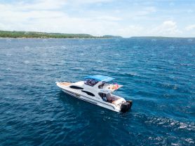 A stunning aerial view of a luxurious yacht cruising through vibrant blue waters, perfect for showcasing boating adventures and island explorations.