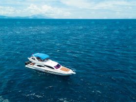 A stunning aerial view of a sleek yacht cruising through deep blue waters, perfect for luxury charters and ocean adventures.