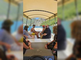 A lively group enjoys a scenic boat ride, surrounded by stunning landscapes — perfect for adventure seekers and group outings on the water.