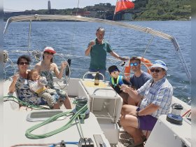 A joyful family celebration aboard a sailboat, raising glasses and enjoying quality time together on the water.