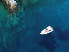 An aerial view of a boat cruising through crystal-clear waters, showcasing a perfect day on the water with friends or family.