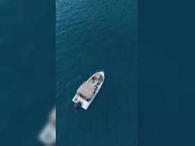 Aerial view of a group enjoying their time on a boat in clear blue waters, perfect for summer adventures and water activities.