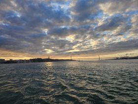 A stunning sunset view over the coastline, showcasing the beauty of the landscape and the tranquil waters — perfect for capturing memorable moments on a boat trip.