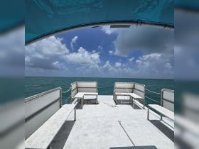 Interior view of a boat's seating area, showcasing comfortable benches and a clear view of the ocean under a bright sky — perfect for relaxing while on the water.