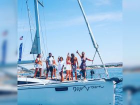 A lively group celebrates aboard the yacht 'My Vision,' raising drinks and enjoying a sunny day on the water — perfect for unforgettable outings and gatherings.
