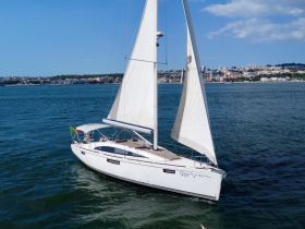 A stunning aerial view of a sleek sailboat navigating through clear waters, showcasing its elegant design and the beauty of sailing.