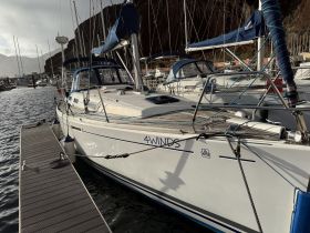 A sleek yacht named '4Winds' docked at a marina, showcasing its elegant design and readiness for sailing adventures.