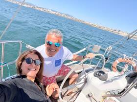 A joyful couple takes a selfie while sailing on a yacht, capturing the essence of a perfect day on the water.