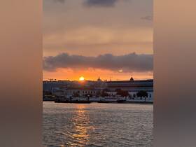 A stunning sunset over the harbor, reflecting golden hues on the water — a picturesque scene perfect for evening boat cruises.