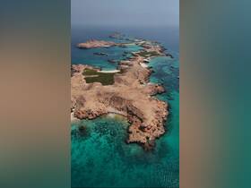 A stunning aerial view of a picturesque coastline with turquoise waters and rocky islands, perfect for showcasing the beauty of nature and potential boating destinations.