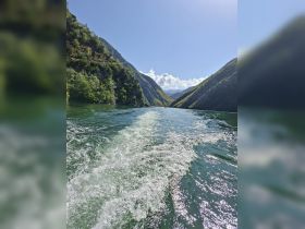 A stunning view of a serene waterway surrounded by majestic mountains, perfect for nature lovers and adventure seekers exploring the great outdoors.