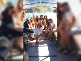 A lively group of friends poses together on a boat, capturing the joy of their adventure on the water. Perfect for showcasing memorable moments during a fun outing.