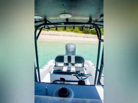 An interior view of a boat's helm and seating area, showcasing the console and steering wheel, perfect for a day on the water.