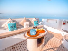 A beautifully arranged seating area on a yacht featuring refreshments and snacks, perfect for a relaxing day on the water.
