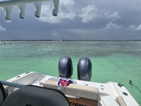 A view from the back of a speedboat, showcasing the clear turquoise waters and distant shoreline, perfect for a day of adventure on the water.