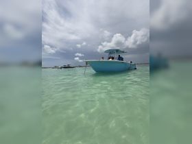 A vibrant boat anchored in crystal-clear waters, with guests enjoying a relaxing day on the water — perfect for summer adventures and family outings.