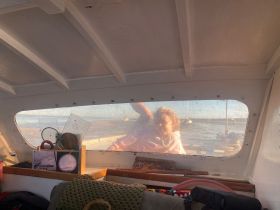 A cozy interior view of a boat's cabin, featuring a child looking out the window, showcasing the inviting atmosphere of boating adventures.