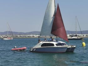 A lively group enjoys a sailing experience aboard a catamaran, showcasing the fun of on-water activities in a beautiful setting.