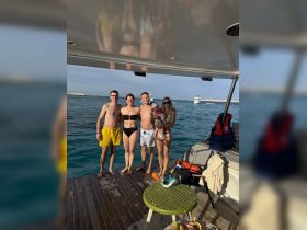 A joyful family poses for a photo on the deck of their boat, enjoying a sunny day on the water — perfect for memorable family outings and adventures.