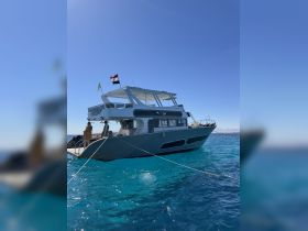A sleek yacht docked in crystal-clear waters, showcasing its modern design and inviting atmosphere for a perfect day on the water.