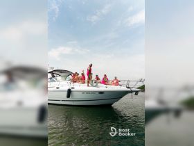 A lively group enjoys a fun day on the SKY DWELLER II, showcasing vibrant outfits and a festive atmosphere on the water.