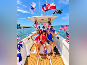 A lively group of friends celebrates on a boat adorned with flags, enjoying a sunny day on the water — perfect for summer outings and festive gatherings.