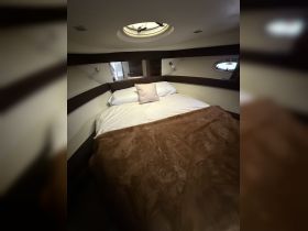 Cozy cabin interior featuring a comfortable bed with soft bedding, perfect for restful nights on the water.