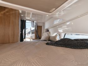 Cozy interior view of a boat cabin featuring a comfortable bed and stylish decor, perfect for relaxing during your maritime adventures.