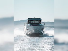 A sleek speedboat cuts through the water, showcasing its dynamic design and performance on a clear day.