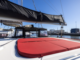 A close-up view of the comfortable seating area on a yacht, showcasing the red cushions and sleek design, perfect for relaxing while enjoying the water.